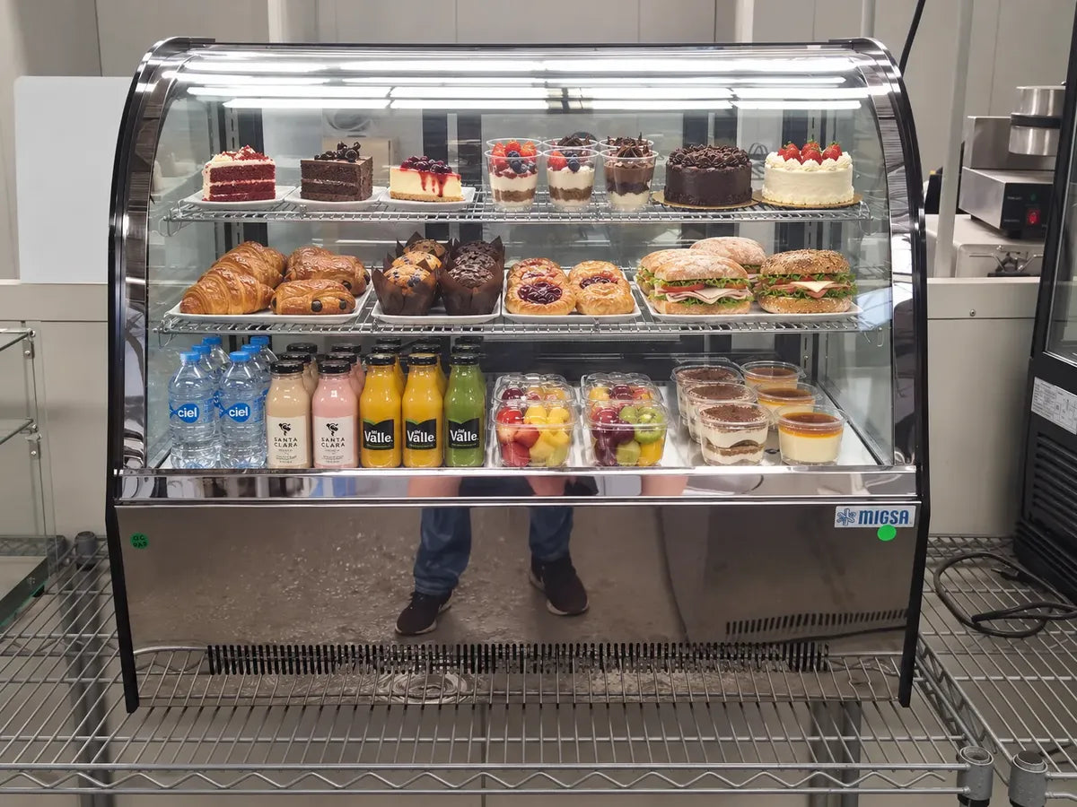 Vitrina refrigerada MIGSA GN-1200CT exhibiendo postres bebidas y alimentos